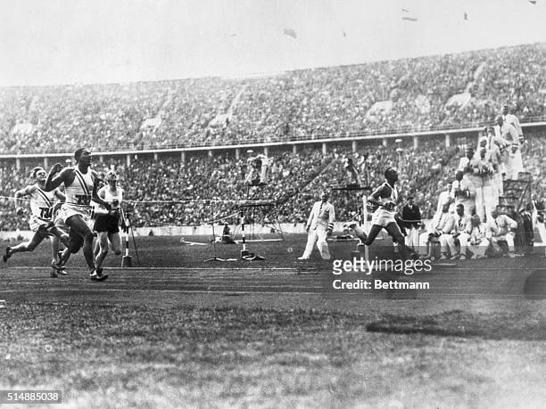 During the 1936 Olympic Games in Berlin, Jesse Owens , of Ohio State University, breaks the tape to win gold in the 100-meter dash in a record time...