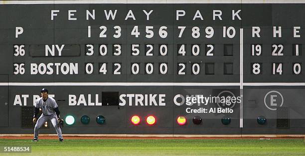 Hideki Matsui of the New York Yankees awaits a play while the scoreboard reads 19-8 Yankees over the Boston Red Sox in the ninth inning during game...