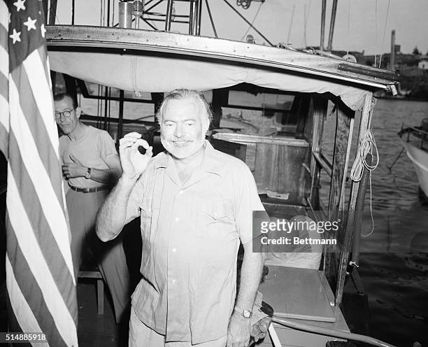 Ernest Hemingway, aboard his boat Pilar, indicates the size of his catch with a big goose egg after the first day of a three-day international...