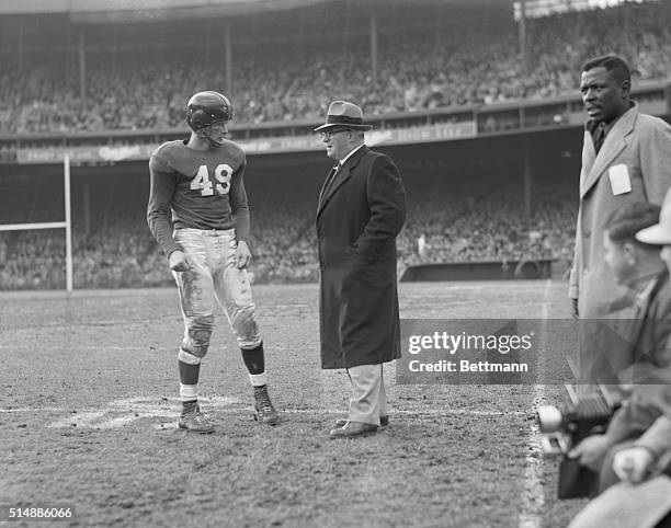 New York Giant's football coach Steve Owen on the sidelines talking to player Tom Landry.