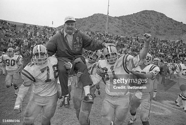 Coach Charlie McClendon is carried off field by two of his players, Ronnie Estay and Jay Michaelson after LSU defeated Iowa State 33-15 in the Sun...