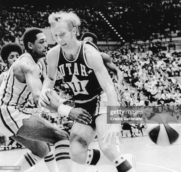 Mel Daniels of the Indiana Pacers reaches in to knock the ball away from Rick Mount of the Utah Stars in an ABA playoff game. Mount started his pro...