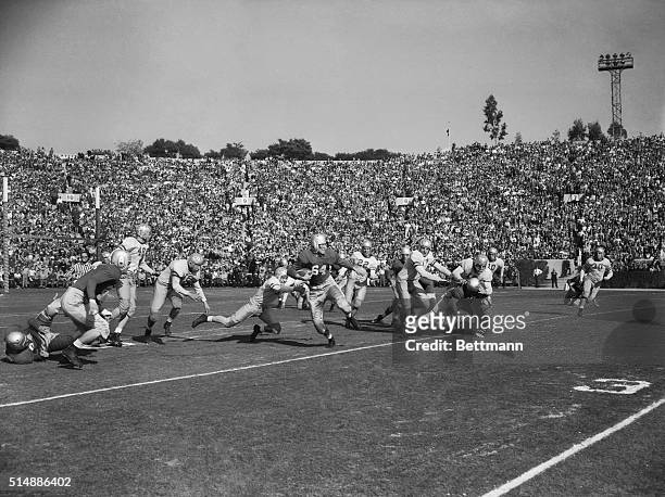In the first play of the Rose Bowl Game, Georgia halfback Lamar Davis eludes UCLA end, Herb Wiener and halfback Ev Riddle to return UCLA's kickoff...