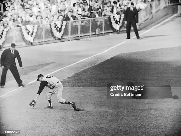 Pittsburgh Pirates third baseman Don Hoak makes a spectacular backhanded grab of a hot smash belted by New York Yankee Bill Skowron in the ninth...