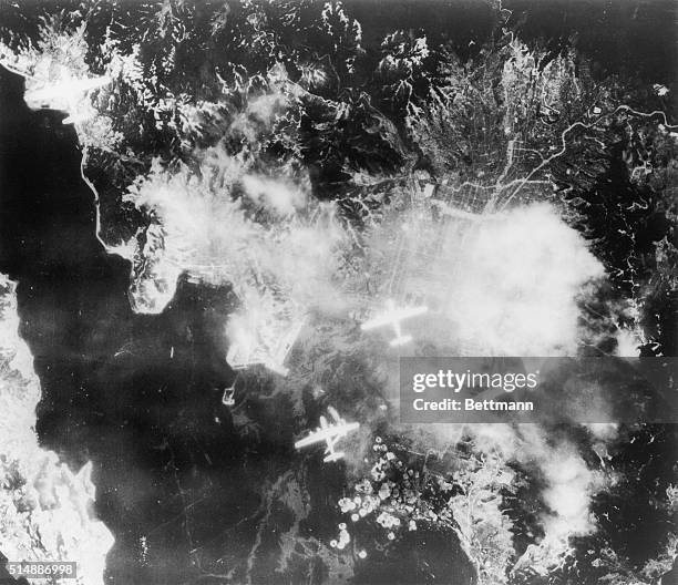 Four B-29 Superfortresses of Maj. Gen. Curtis E. LeMays 21st Bomber Command, drop their bombs drop their bombs during a raid on the Kure Naval...