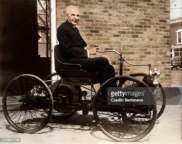Henry Ford sits in his old pride and joy, the 1896 Quadricycle, outside his shop on Bagley Avenue in Dearborn, Michigan.