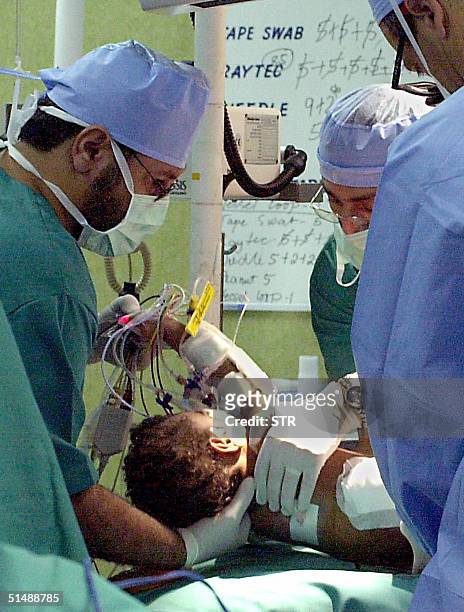 Doctors treat one of the two-year-old Sudanese twins, who were joined at the buttocks and spinal cord and shared the same penis and anus, after an...