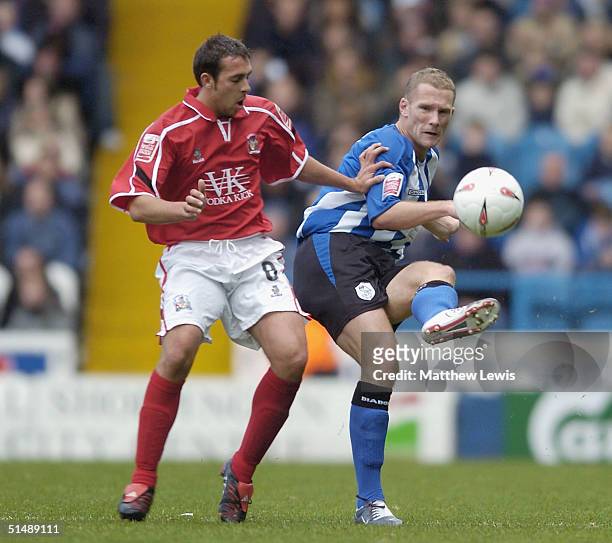 Paul Smith of Sheffield clears the ball away from Michael Chopra of Barnsley during the Coca-Cola Division One match between Sheffield Wednesday and...