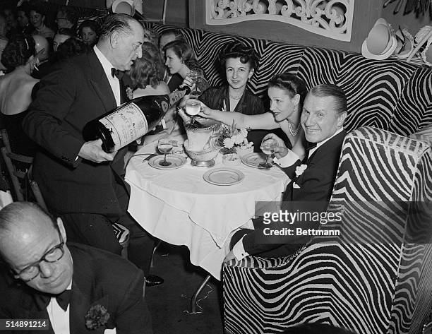 John Perona , owner of El Morocco nightclub, 154 East 54th Street, New York City, celebrating New Year's Eve with guests.