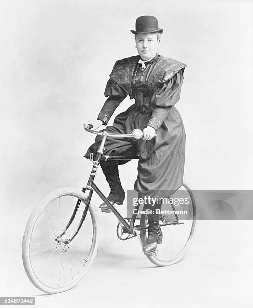 The New Woman: Bloomer garbed, derby hatted, on bicycle.