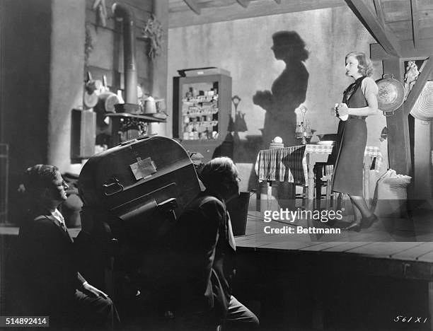An unusual camera study of Greta Garbo appearing in a scene for Susan Lenox, Her Fall and Rise. MGM Director, Robert Z. Leonard may be seen at the...