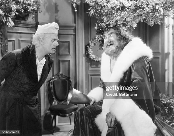 Reginald Owen, playing Scrooge, confronts the Ghost of Christmas Present, played by Lionel Braham, in the 1938 MGM production of "A Christmas Carol."...
