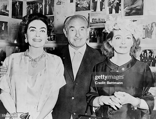 Entertainer Jack Warner is flanked by Joan Crawford and Bette Davis .