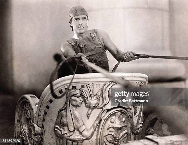 Ramon Novarro holding the reins of his chariot in a scene from Ben Hur.