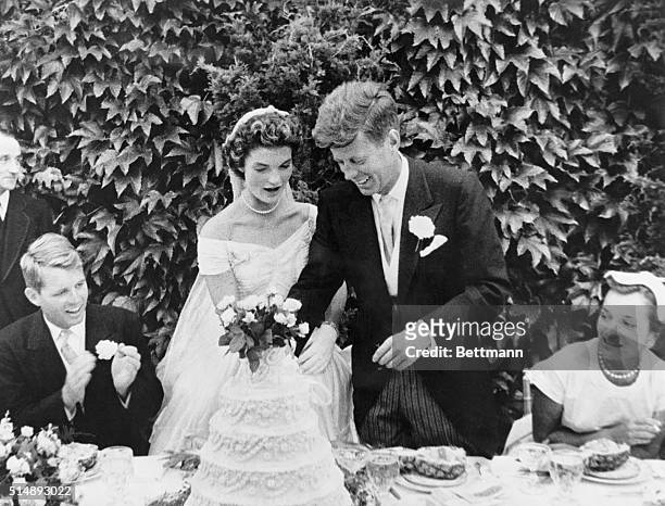 John F. Kennedy and Jacqueline Bouvier cutting their wedding cake after their marriage in Newport, Rhode Island. John Kennedy was then U.S. Senator...