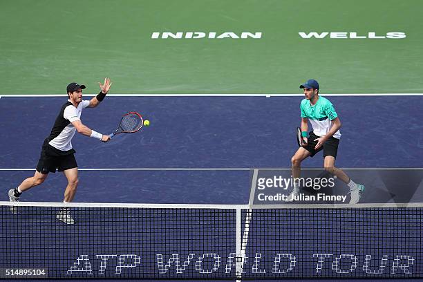 Andy Murray and Colin Fleming of Great Britain in action against Milos Raonic of Canada and John Isner of USA in the doubles during day five of the...