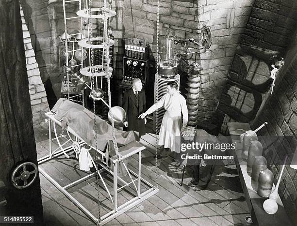 Edward Van Sloan as Dr. Waldman, Colin Clive as Dr. Henry Frankenstein, and Dwight Frye as his assistant Fritz, preparing to bring their monster to...