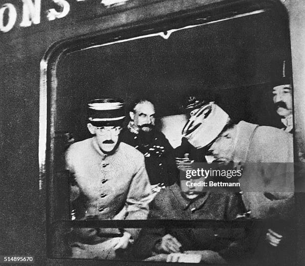 Supreme Allied Commander Marshal of France, Ferdinand Foch, is seen through the window of the Compiègne Wagon as he signs the Armistice ending World...