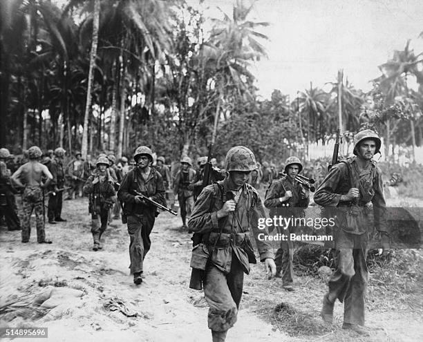 Dog Tired Devil Dogs. Tired and unshaven Marines, who hit the beach at Torokina Point, Bougainville, plod their weary way out of the Jungle from the...
