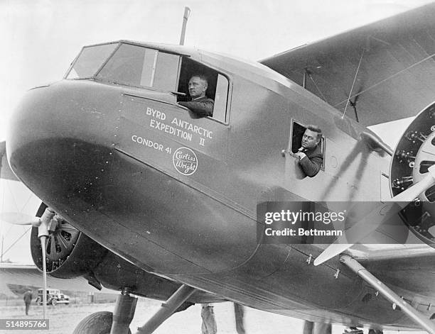 Rear Admiral Richard E. Byrd , in cockpit of plane which he flew in his second expedition to the Antarctic. On the right is Harold June, chief pilot.