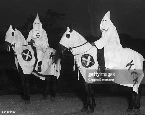 Two Klu Klux Klansmen on horseback.