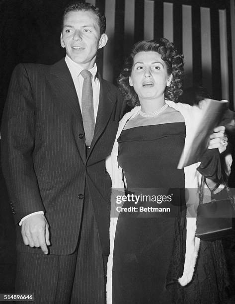 With Hollywood film stars after dark...Frank Sinatra and his own wife, Nancy, about to enter Ciro's night club in Hollywood, where film stars...