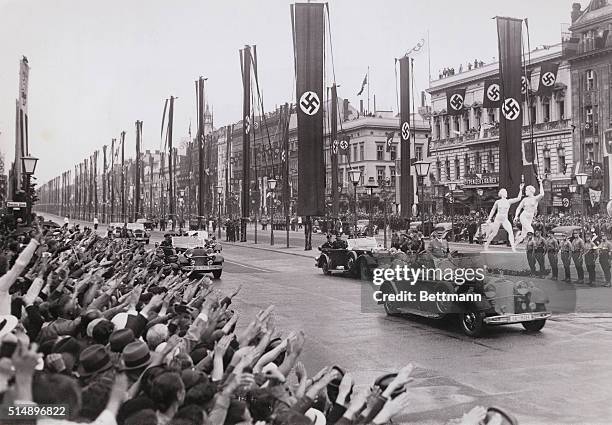 Berlin, Germany: Auto of Adolf Hitler and other important officials passes on the way to the opening of the Olympics, the famous "Unter Den Linden"...