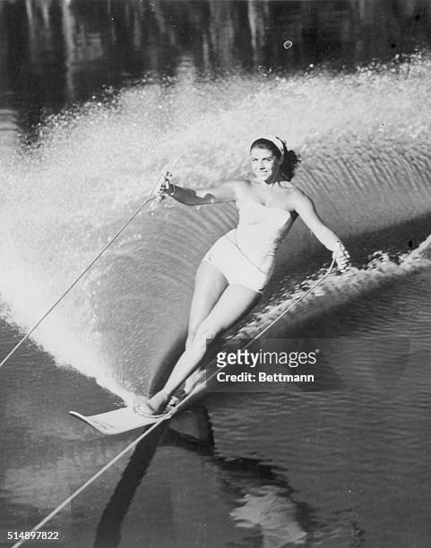 Splashing up a pretty spray at Cypress Gardens, Forida, is lovely Swiss water skier Marina Doria of Geneva. She was tuning up on one ski for the...