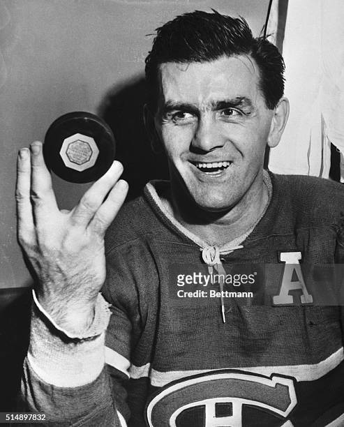 Maurice "The Rocket" Richard, of the Montreal Canadiens, shows the puck with which he scored the 400th goal of his career. Richard made history with...