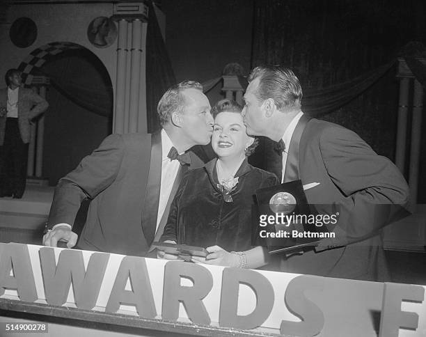 Actress Judy Garland is kissed by Bing Crosby and Red Skelton after she and Bing received the 1955 Look magazine awards for the best actress and...