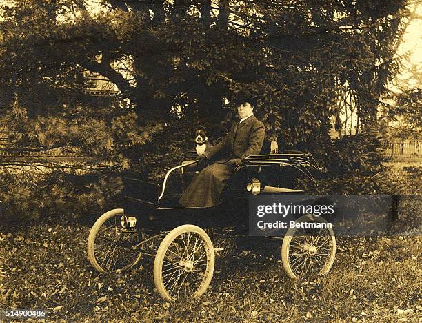 Julia Marlowe seated with dog in Columbia electric car.