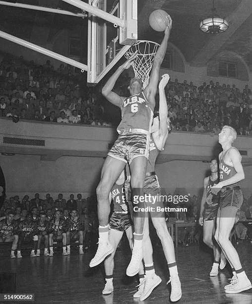 All America candidate Bill Russell of the University of San Francisco, makes a high backhand shot during the February 14th game with the University...