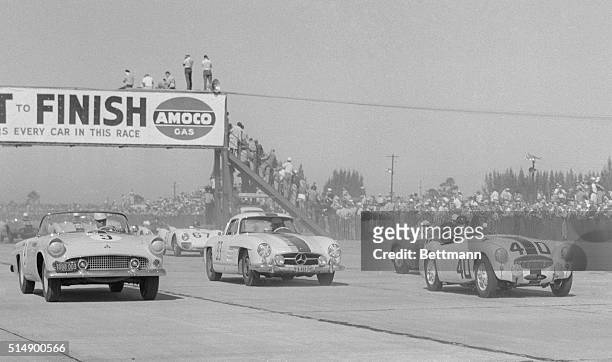 Crowds line the fence at the start of the Florida International Twelve-Hour Grand Prix Endurance Race at Sebring, Florida. In car, is Fred Scherer of...