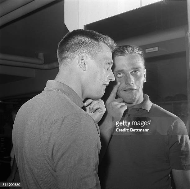 Yankee outfielder Roger Maris views his left eye in mirror after he retired from May 22nd New York-Baltimore game after he retired from May 22nd New...