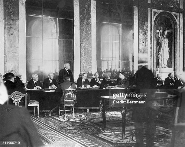 French Premier Georges Clemenceau rises to speak at the signing of the Treaty of Versailles in 1919. U.S. President Woodrow Wilson is seated to...