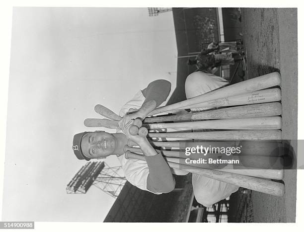 Brooklyn, New York: Duke Snider, Center fielder and slugger of the league-leading Brooklyn Dodgers, poses with a load of lumber at Ebbets Field...