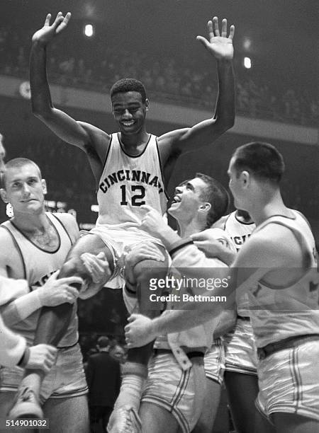 Waving his arms in jubilation, Cincinnati basketball ace Oscar Robertson is carried on the shoulders of joyful teammates after landing his team to...