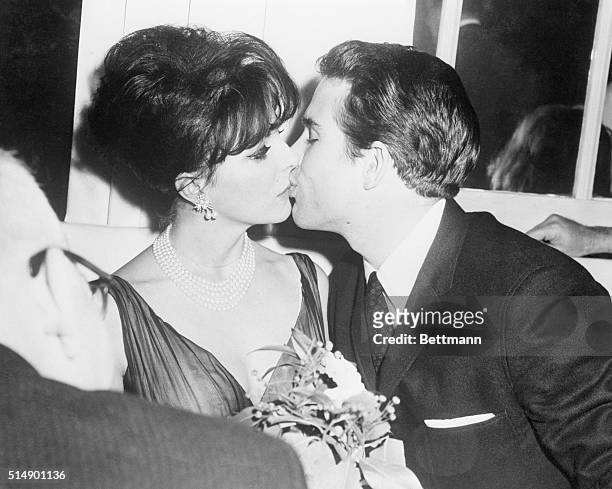 Actress Joan Collins and actor Warren Beatty kiss at the Harwyn Club.