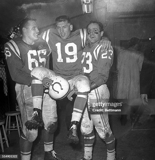 Teammates Steve Myhra and Carl Tasoff carry Baltimore quarterback Johnny Unitas into the dressing room after the Colts defeated the Giants 31-16 in...