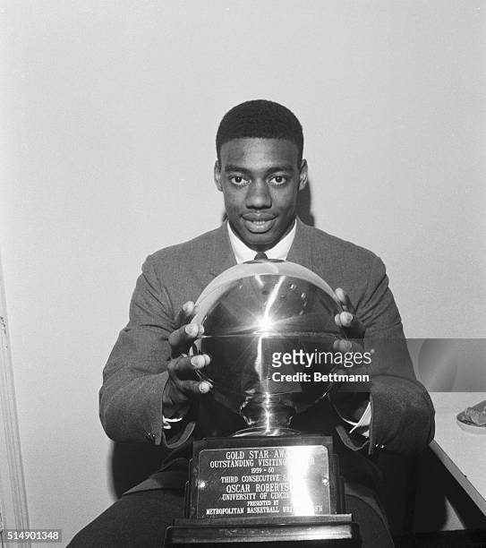 Oscar Robertson, of Cincinnati, holds his Gold Star award at the Manhattan Hotel here, March 13th. Robertson received the award during the annual...