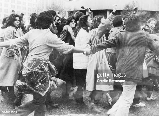 Protesters against the veil, protected by young men, march in central Tehran March 10th on the third day of demonstrations for women's rights in the...