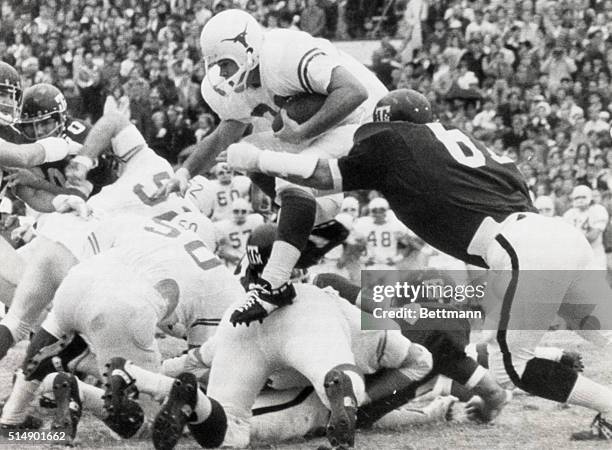 Texas Longhorn halfback, Billy Dale hurdles the Texas Aggie line for a pickup of 7 yards to the Aggie 37 in the first period of play. Making the stop...