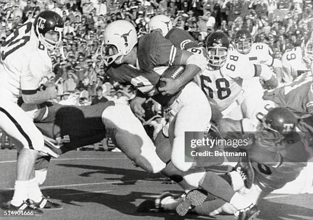 Steve Fleming who replaced the Longhorns inuured Steve Worster evades two Aggie tacklers as he spritns 50 yards down the sidelines in the 3rd period...