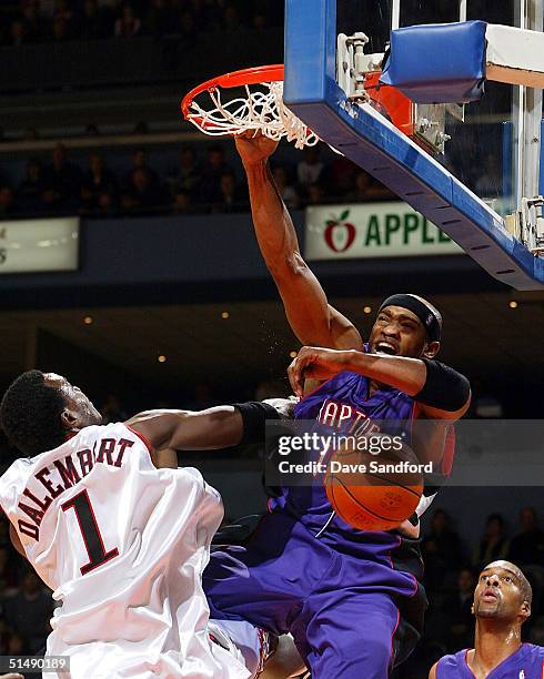 Vince Carter of the Toronto Raptors dunks the ball against Samuel Dalembert of the Philadelphia 76ers at the John Labatt Centre on October 17, 2004...