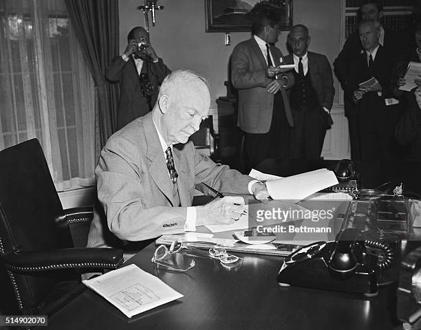President Eisenhower is shown signing the Middle East Resolution, popularly known as the "Eisenhower Doctrine" at the White House yesterday. The...