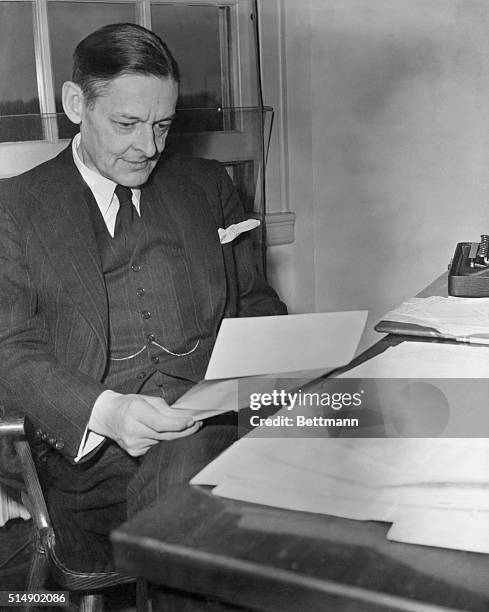 POET, AT HIS DESK READING A MANUSCRIPT.