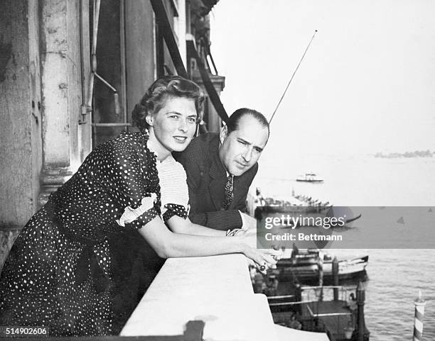 Venice, Italy: From a balcony of the Grand Hotel, Ingrid Bergman, movie star, and Roberto Rossellini, Italian director who she wed after divorcing...