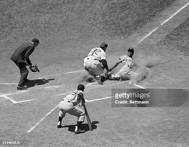 Chicago, IL: Pirates' outfielder Roberto Clemente is tagged out at the plate by Cub catcher Harry Chiti on Frank Thomas' hit to left field, in the...