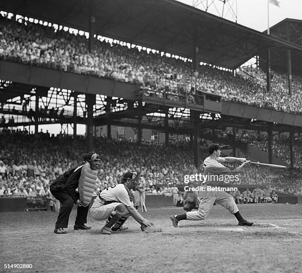 Washington, D.C.: Joe DiMaggio, ball-thumping outfielder of the New York Yankees, slashes out the single that broke George Sisler's nineteen-year-old...