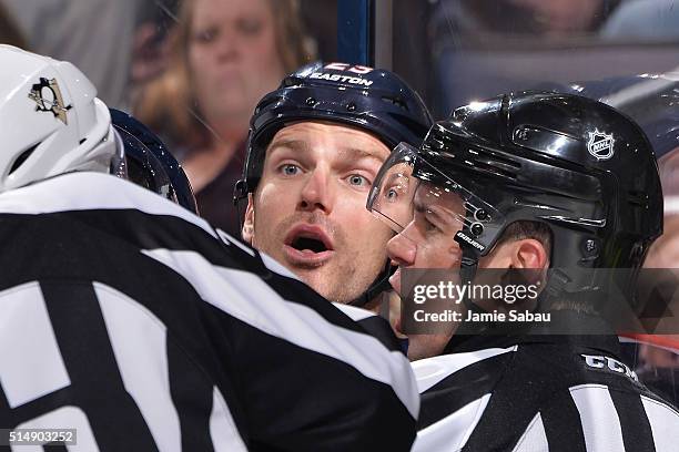 Referee Ian Walsh holds back David Clarkson of the Columbus Blue Jackets as he shares a few words with a member of the Pittsburgh Penguins following...